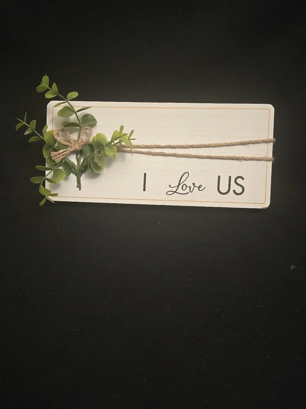 White 'I Love Us'  Sign with Green Faux Foliage
